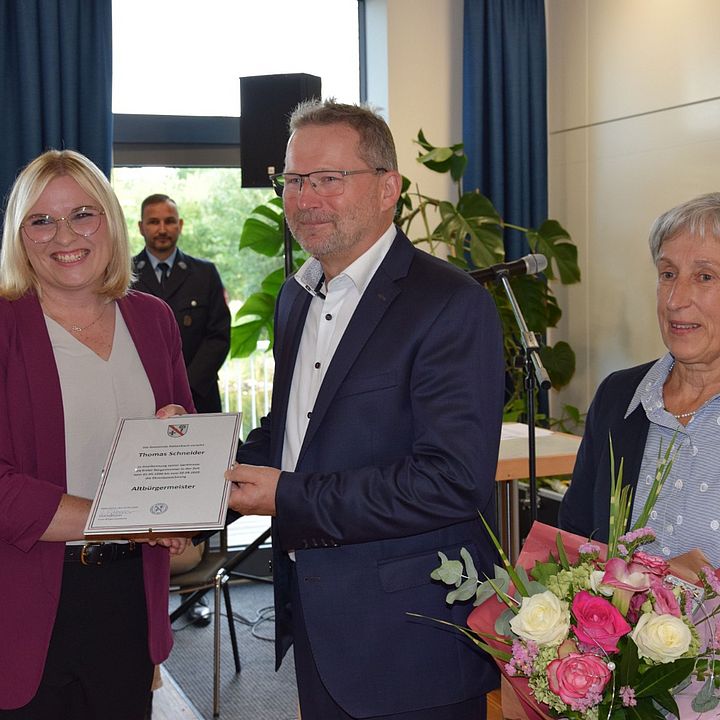 Auf dem Bild sind 1. Bürgemeisterin Lisa Schlosser, Altbürgermeister Thomas Schneider mit Ehefrau Gertraud Schneider bei der Übergabe der Ernennungsurkunde zum Altbürgemeister von Schneider zu sehen. Die Ernennung erfolgte im Rathaussaal von Röttenbach.