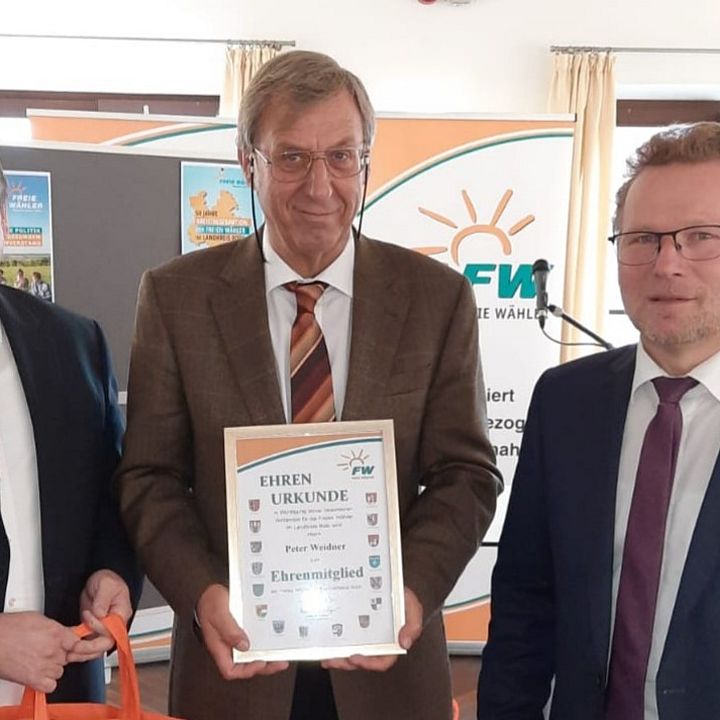 Mit einem verhaltenem, aber freudigem Lächeln nimmt Peter Weidner die Urkunde entgegen, links Hermann Kratzer, rechts Thomas Schneider